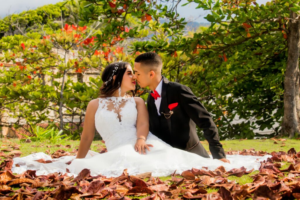 Bride and Groom Sitting in a Garden among Autumnal Leaves